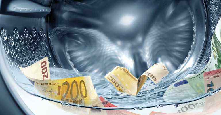 A decorative image showing banknotes in a washing machine