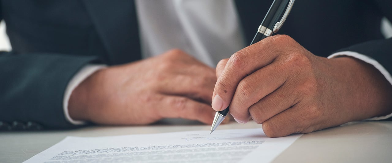 A male professional signing a contract