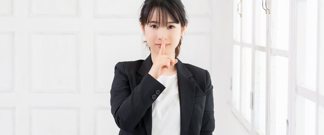 Female businessperson with her finger on her nose