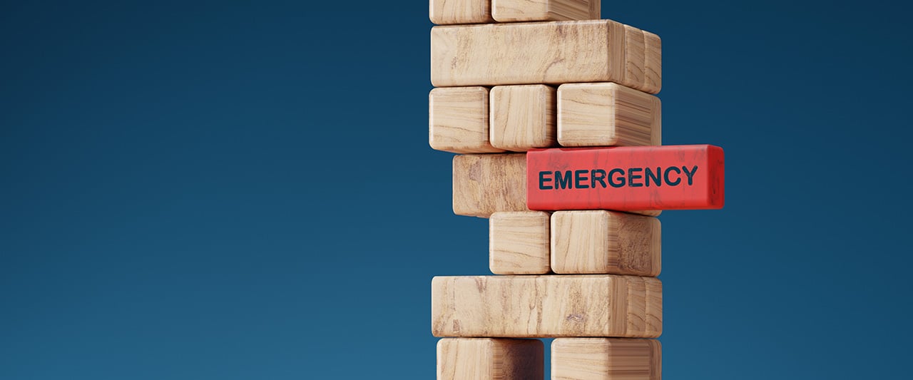 Wooden blocks resting on a red block marked 'emergency'