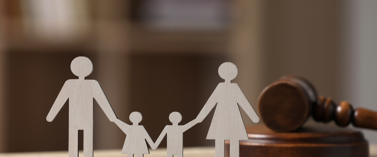 Images of a family cut out in paper next to a gavel