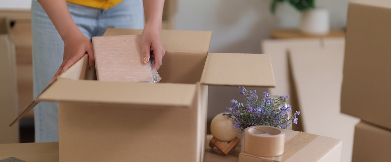 A person packing contents of a house into boxes