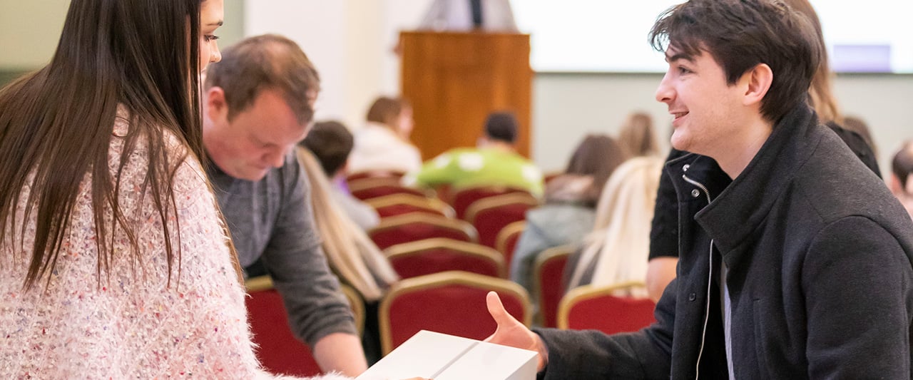 A trainee on the PPC collects course materials from a staff member
