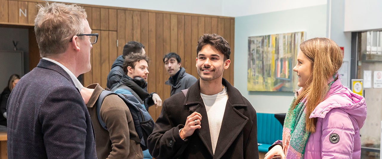 A trainee having a friendly conversation with a course manager at the Law School