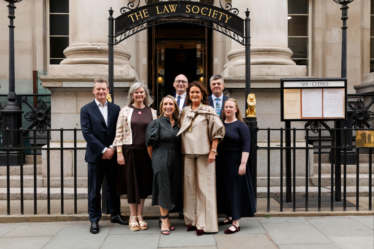 People standing in front of an arched gate that says The Law Society