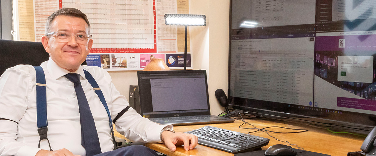 A man working in a legal office with screens and dictation tools